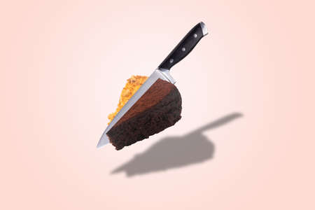 knife cuts conjoined honey and chocolate cake, levitating pastry, background photo of sweet dessertの写真素材