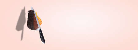 knife cuts conjoined honey and chocolate cake, levitating pastry, background photo of sweet dessert, panoramic imageの写真素材