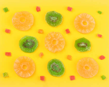 Kiwi and pineapple dried fruits near to candied fruits, sweet colorful backgroundの写真素材