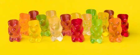 Multicolor fruit gummy candy in the form of a grizzly bear. Jelly Bear over yellow background, panoramic imageの写真素材