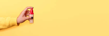 foundation in hand over yellow background, concept of skin problems, beige concealer for makeup, panoramic mock upの写真素材