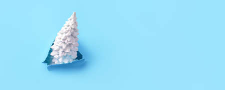 Christmas tree on a blue background, minimalist concept, panoramic card with a place for text.の写真素材