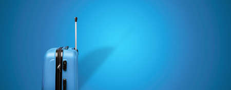 blue travel suitcase over blue background, panoramic mock up imageの写真素材