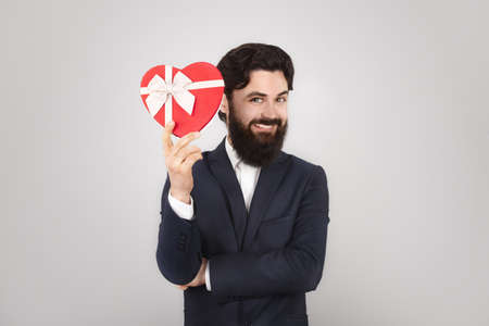 Happy Valentine Day, man holding present in shape of heart, 14 February Holiday Conceptの写真素材