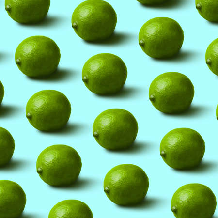 fresh, green limes pattern on blue background. Minimal flat lay food texture