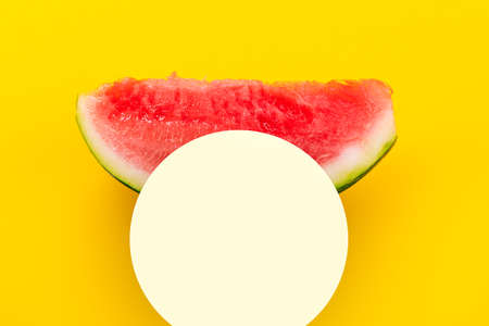 Watermelon slice over yellow background. Summertime concept. Mockup with space for text.の写真素材