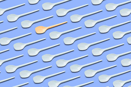 Flat lay composition with plastic spoons on blue background. Table setting