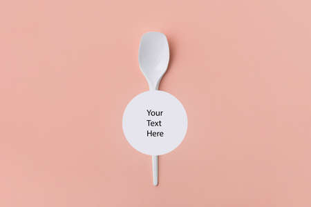 white recyclable plastic spoon on pink background with space for text, ecology problem conceptの写真素材