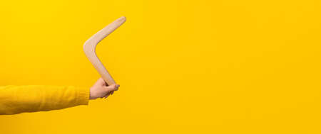 boomerang in female hand over yellow background, panoramic mock-upの写真素材