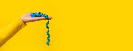 measuring tape on hand over yellow background,  panoramic mock-up, slimming concept