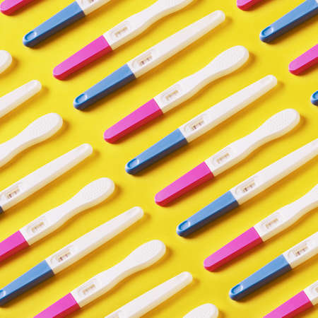 pattern with positive pregnancy tests over yellow background