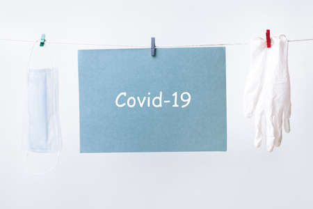 hanging on a rope medical mask with protective gloves, covid-19 concept, pandemic in the worldの写真素材