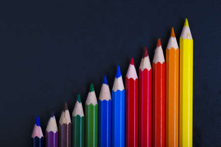 Coloured pencils lined in a increase on dark backgroundの写真素材