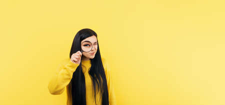 Beautiful woman looking through a magnifying glass, searching concept, panoramic mock-upの写真素材