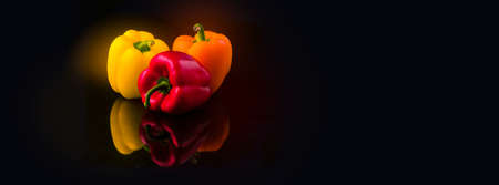 yellow, red and orange pepper paprika on a black background