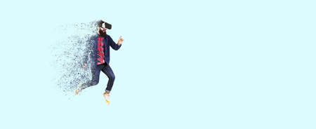 Full length portrait of a jumping bearded hipster in glasses of virtual reality, man dispersing and disintegrating into particles,concept of new technologiesの写真素材