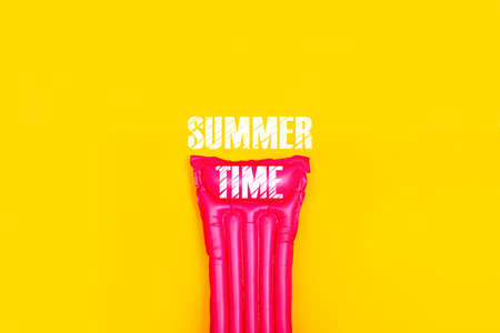 pink swim mattress on a yellow background, concept of summer vacation at sea, concept summer timeの写真素材