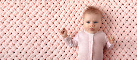 Beautiful newborn girl on a pink knitted plaid, panoramic mock-up image