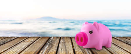Pink piggy bank on wooden boardの写真素材