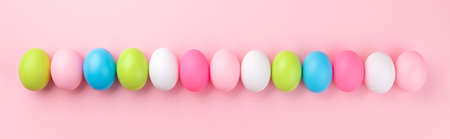 Set of colorful Easter eggs over pink background, panoramic image