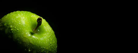 fresh green apple with water drops over black background, panoramic mock-upの写真素材