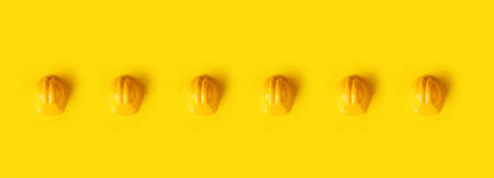 hard hats over trendy yellow background, panoramic image