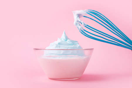 cream with whisk over pink background, dessert conceptの写真素材