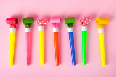 party whistles over pink background, birthday and celebration conceptの写真素材