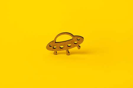 wooden symbol UFO over yellow backgroundの写真素材
