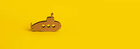 toy wooden submarine over yellow background, panoramic mock-upの写真素材