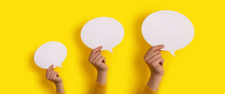bubble speech layout in hand over yellow background, panoramic mock-upの写真素材