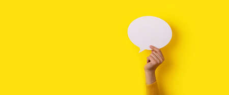 bubble speech layout in hand over yellow background, panoramic mock-up
