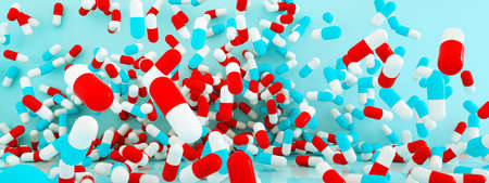 Many capsule pills flying over blue background, 3d render, panoramic imageの写真素材