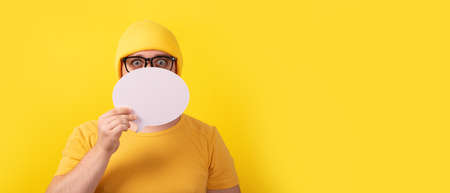 caucasian man holding speech bubble with empty space for text over yellow background, panoramic layoutの写真素材