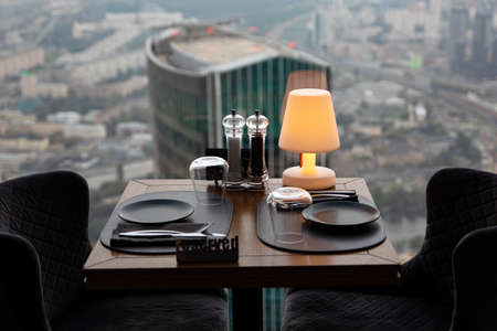 Dinner at sunset with panoramic views of the Moscow business center. Dinner on the background of the city. Restaurant overlooking downtown. Romantic setting, Moscow, Russiaの写真素材