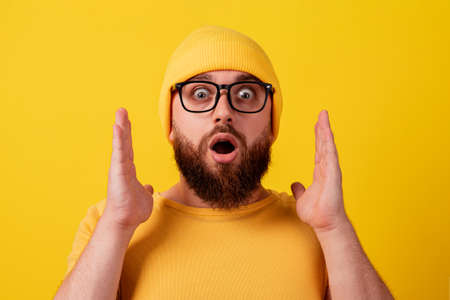 surprised man in glasses over yellow background, wow emotion, concept of promotions or big discountsの写真素材