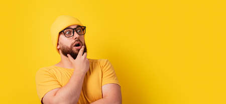 shocked thinking man in glasses looking aside, panoramic layoutの写真素材