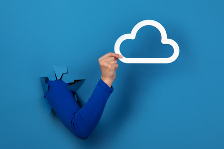 hand holding cloud storage over blue background