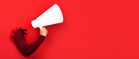 hand holding megaphone over red background, panoramic layoutの写真素材