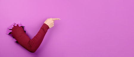 hand showing over empty space over purple background, panoramic layoutの写真素材