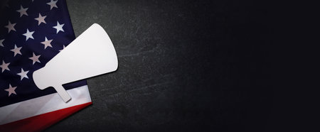 Advertising campaign in USA concept, megaphone on US flag over marble background, panoramic layoutの写真素材
