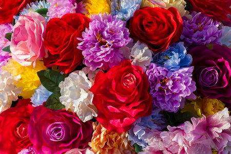 Bright, colorful assortment of artificial flowers in full bloom, ideal for decoration, background, or festive design use.の写真素材