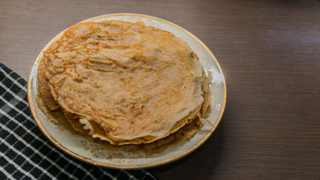 pancakes on a plate on the brown table