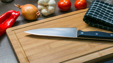 big kitchen Knife on cutting board with vegetablesの写真素材