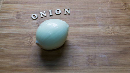 Top view of fresh white onion and vegetables on cutting board, kitchen backgroundの写真素材