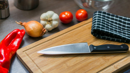 big kitchen Knife on cutting board with vegetablesの写真素材