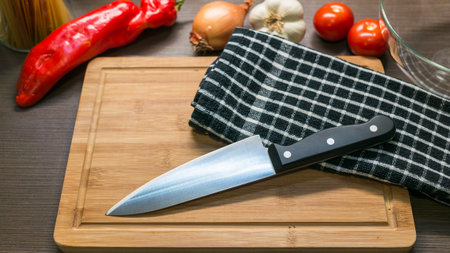 big kitchen Knife on cutting board with vegetablesの写真素材