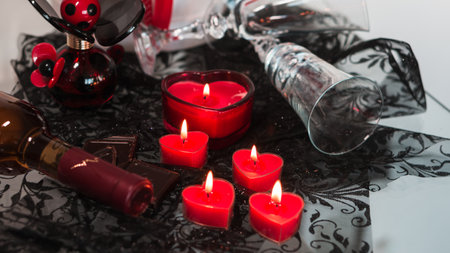 Valentine's Day Romantic Dinner. Date. Table setting with Champagne in two glasses, candles and gift box over holiday red background with heartsの写真素材