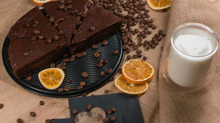 slices of chocolate brownie cake with cap milk and coffee beanas on wooden tableの写真素材