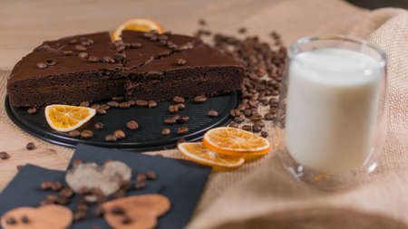 slices of chocolate brownie cake with cap milk and coffee beanas on wooden tableの写真素材